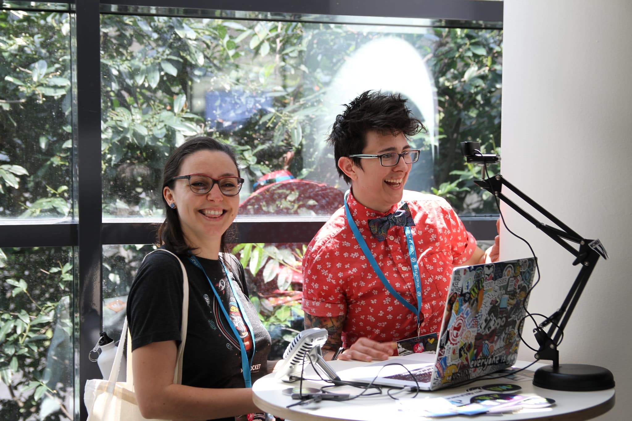 Alice Orru e Tracy Apps sorridono di fronte al computer mentre registrano un podcast al WordCamp Europe 2019