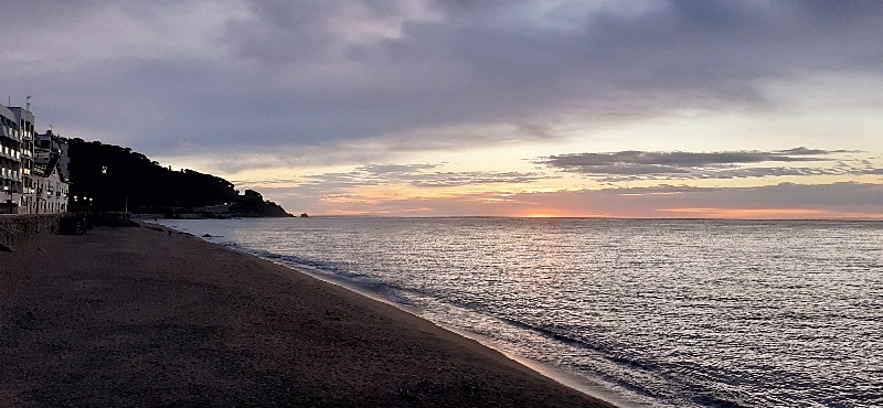 Uno spicchio di sole che spunta dal mare color argento