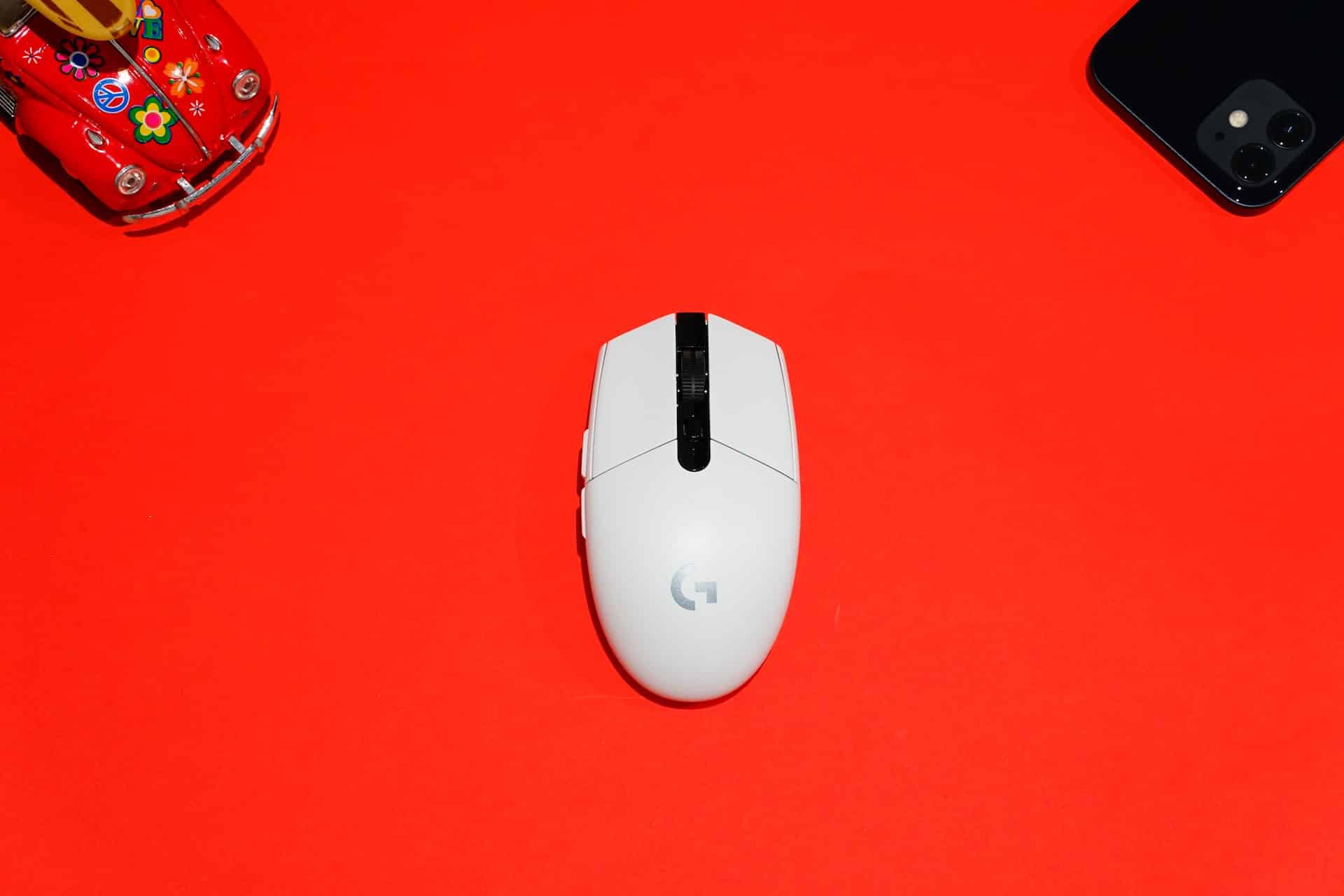 Un mouse bianco con il logo di Google al centro, su sfondo rosso.